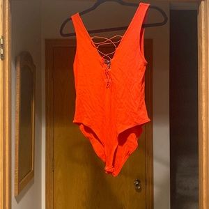 Orange bodysuit, with deep v detailing, full coverage bottom with snap closure